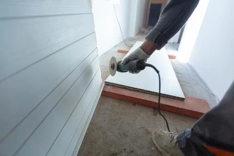 Worker is using angle grinder in apartment that is under construction Stock Photos