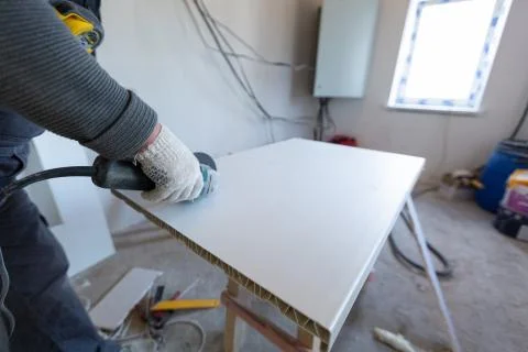 Worker is using angle grinder in apartment that is under construction Stock Photos