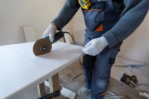 Worker is using angle grinder in apartment that is under construction Stock Photos