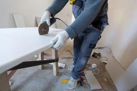 Worker is using angle grinder in apartment that is under construction Stock Photos