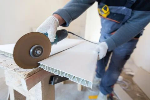 Worker is using angle grinder in apartment that is under construction Stock Photos