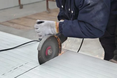 Worker using angle grinder, construction site Fotos Stock
