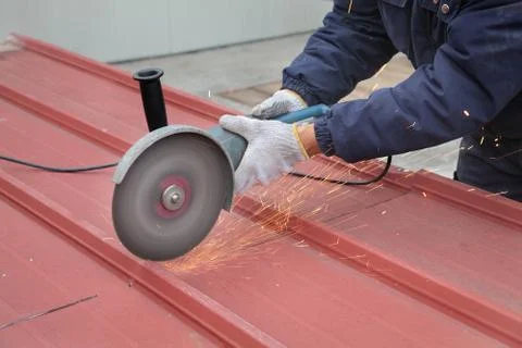 Worker using angle grinder, construction site Stockfoto's