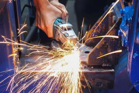 Worker Using an Angle Grinder Creating Bright Sparks. Stock Photos