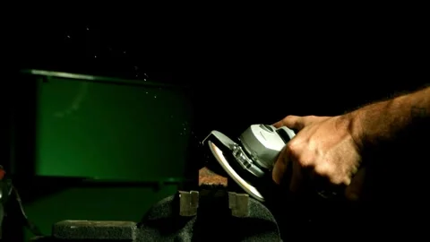 Worker using an angle grinder to cut metal tool Stock Footage 327788829