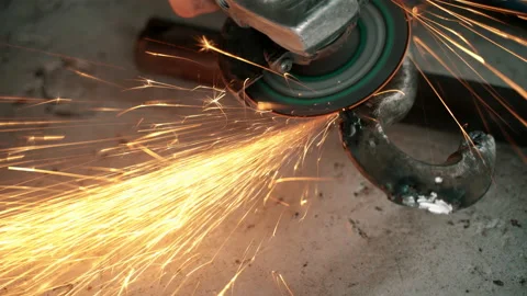 Worker using angle grinder in factory and throwing sparks Stock Footage 140713976