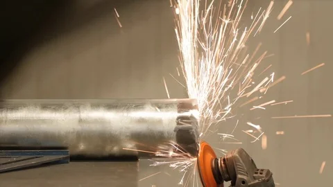 A worker using an angle grinder in a metal machine workshop Stock Footage 69879633