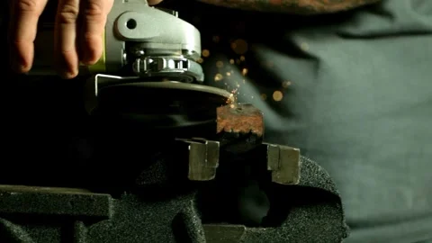 Worker using angle grinder on metal piece in vise Stock Footage 327514469