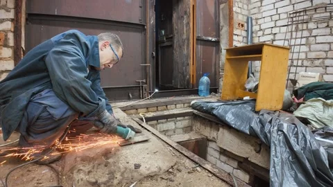 Worker using angle grinder on metal in garage Vidéo 335285608