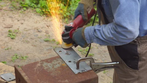 Worker Using Angle Grinder on Metal Plate Outdoors Video stock 336676963