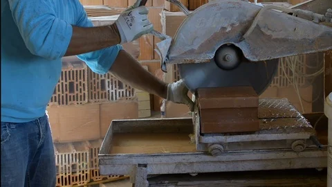 Worker using an angle grinder or circular saw cutting bricks in construction Stock Footage 98300427