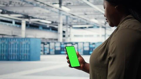 Worker using app on mockup phone to check server hub energy consumption 스톡 사진