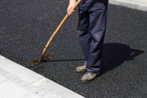 Worker using asphalt lute Stock Photos