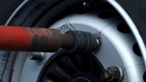 Worker using automated tool twists large bolts on car wheel, replacing wheel Stock Footage 119053065