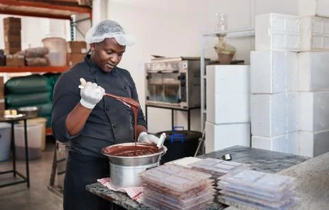 Worker using a bain marie to melt chocolate Stock Photos