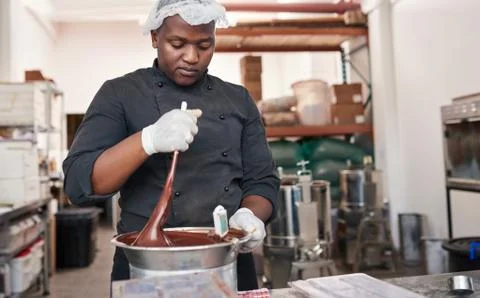 Worker using a bain marie to mix melting chocolate Stock Photos