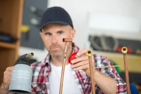 Worker using blowtorch for soldering copper fittings Stock Photos