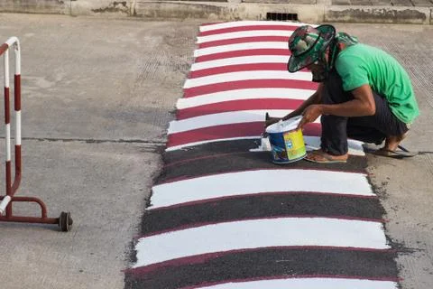 Worker using brush for painting white line on the road Stock Photos