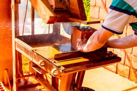 Worker is using circular diamond blade saw to cut red brick, block Stock Photos