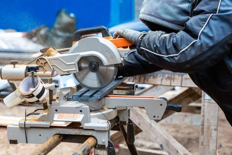 Worker Using Circular Saw on Construction Site in Cool Weather Stock Photos