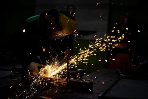 Worker using a circular saw to cut a square metal tube Stock Photos