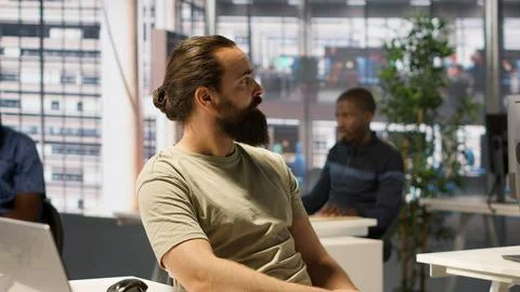 Worker using computer during job shift, being interrupted by manager Stock Photos