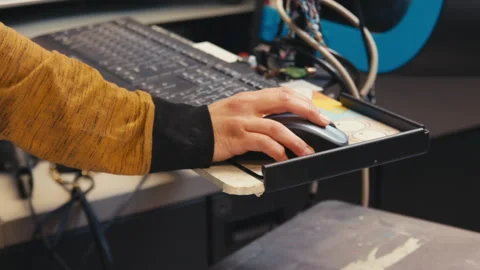 Worker Using Computer Mouse to Operate Printing Machine in Modern Apparel Print Stock Footage 318716069