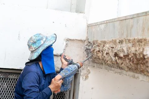 Worker using concrete drilling machine. Stock Photos