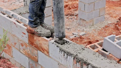 Worker using concrete vibrator on construction site to ensure proper settling of Stock Footage 320329452