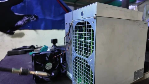 Worker using cordless drill to assemble a crypto mining machine rig Stock Footage 327323935