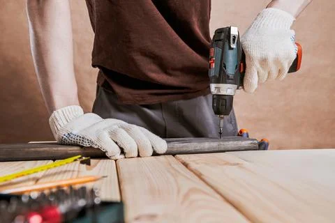 Worker Using Cordless Drill on Wooden Beam Stock Photos