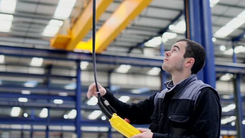 Worker using crane control in a factory Stock Footage 260354107