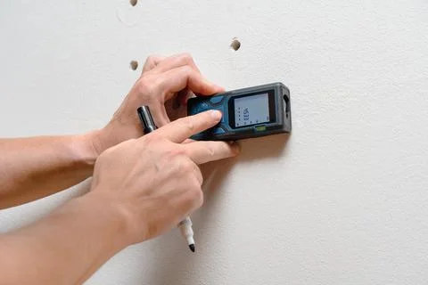 Worker Using Digital Wall Scanner And Measuring Studs and Wires Fotos de archivo