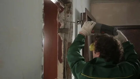 Worker using drill for dismantling old door Stock Footage 70913613