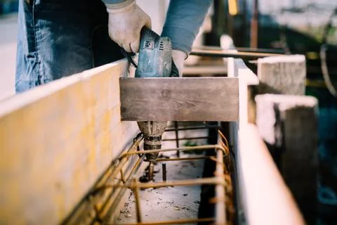 Worker using a drilling power tool on construction site and creating holes Stock Photos