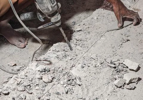 Worker Using Electric Drill on Concrete Surface During Construction Worksa Stock Photos