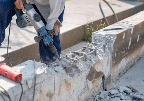 Worker using electric hammer drill to cut the wall concrete. Stock Photos