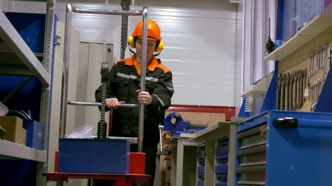 Worker is using equipment in workshop surrounded by safety gear and tools Stock Footage 277866043