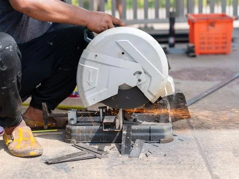 A worker is using a fiber cutting machine to cut a metal workpiece. Stock Photos
