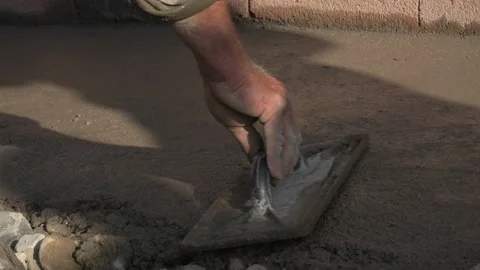 Worker using float trowel to level surface of concrete Stock Footage 220985663