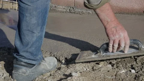 Worker using float trowel to level surface of concrete Stock Footage 220987418