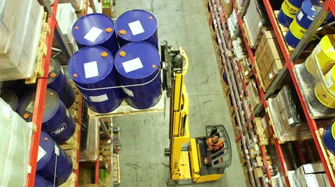 Worker using a forklift truck to move barrels inside a storage warehouse Stock Footage 54972644