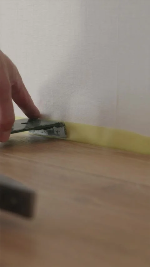 Worker using framing square tool to align laminate floor boards Stockbeeldmateriaal 346396761