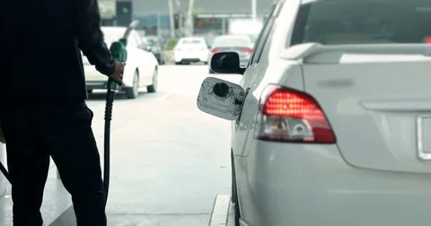 Worker using the fuel nozzle supply pumping oil to car at the gas station Stock Footage 84258177
