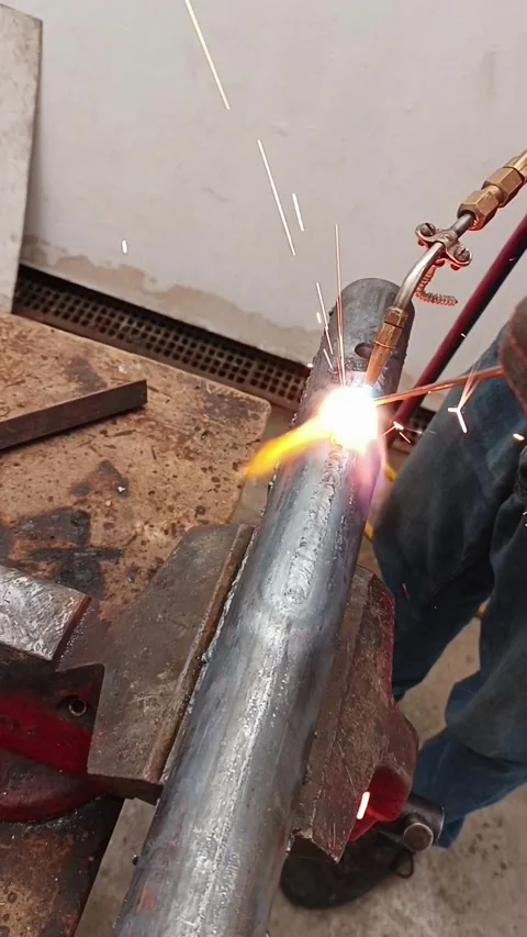 Worker using gas torch and rod for metal welding in workshop Stock Footage 339982013