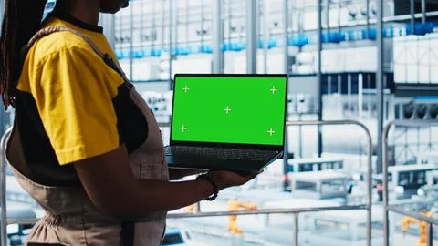 Worker using green screen laptop in smart factory, collecting and analyzing data Stock Photos