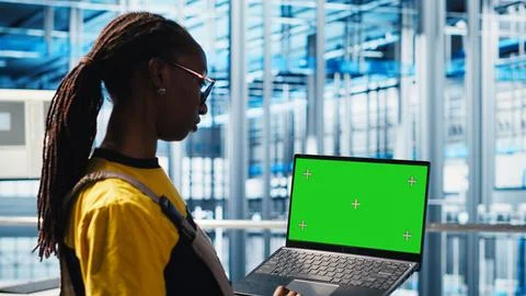 Worker using green screen laptop in smart factory, collecting and analyzing data Stock Photos