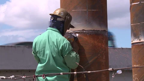 Worker using grinder to smooth welds at construction site Stock Footage 348183904