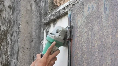 Worker using the grinding tool to cut the joint on the steel door. Stock Footage 287881650