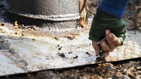 Worker using hands screws to repair metal roof Stock Photos